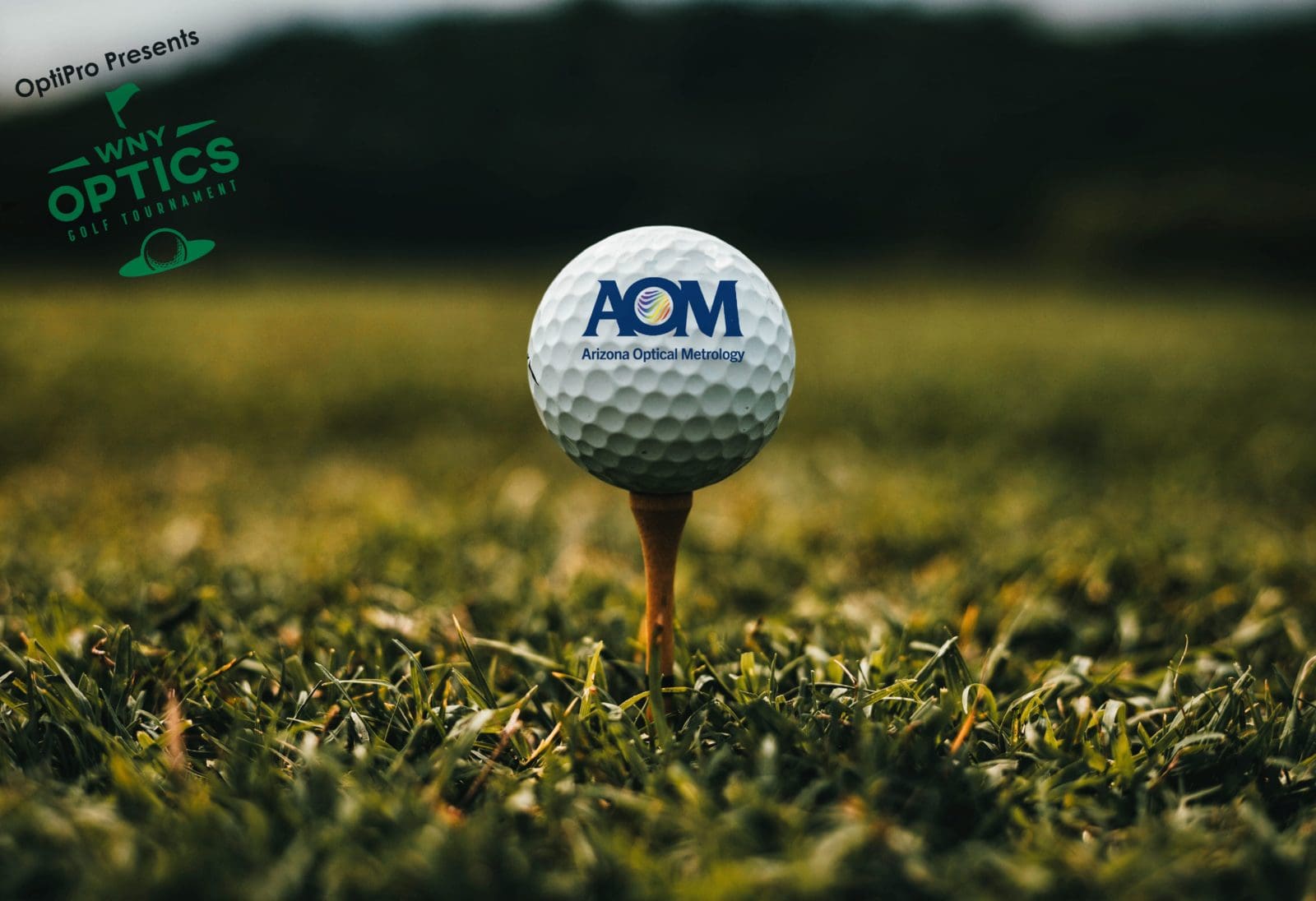 A close up of a golf ball with the AOM logo sitting on a tee