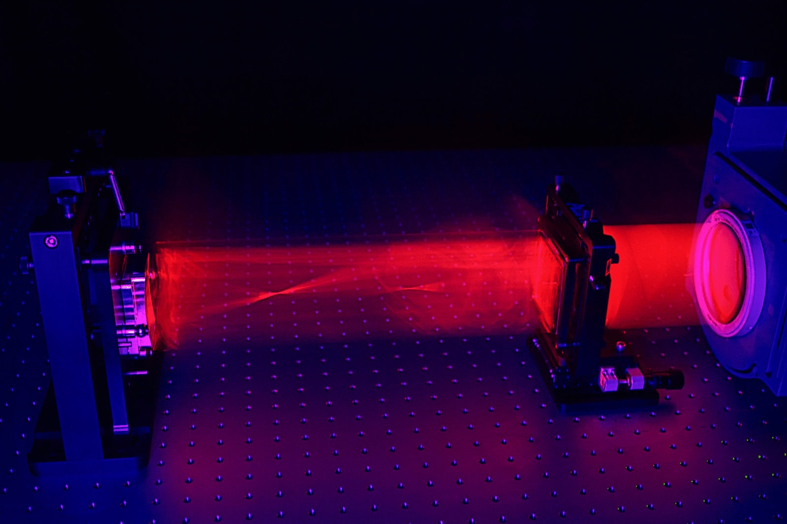 Laser beam of interferometer shining through a computer-generated hologram (CGH) to create a diffractive wavefront to measure a freeform optic.