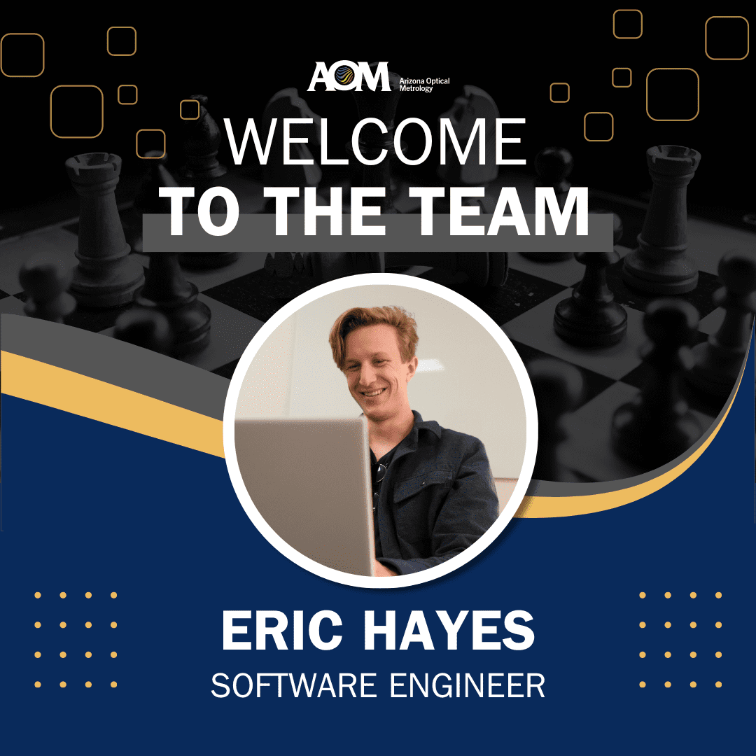 Eric Hayes smiles behind his laptop screen in an image atop a chess board background that says "Welcome to the team"