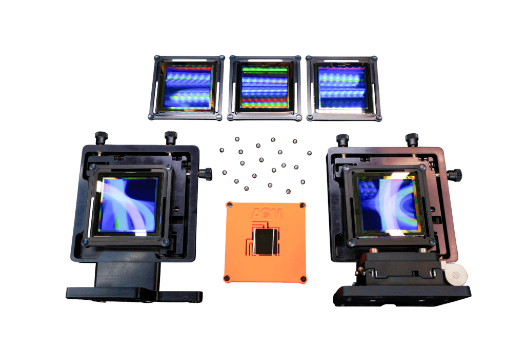 The contents of the AOM 3-inch cylinder kit, including 5 holograms, 2 stages, and 1 cylinder optic in a fixture with magnetic balls.